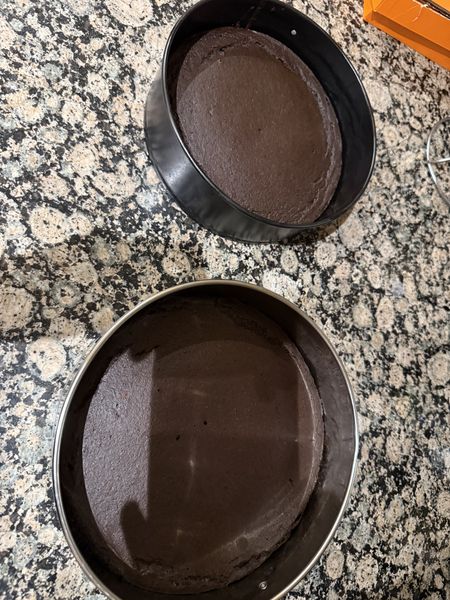 my boyfriend doesn't eat sugar, so every cake i make for him is a little experiment. this one is dates and cocoa and nothing else — the small one was the test run and the big one is the real thing, cooling on my mom's counter. do i risk a date caramel between the layers or keep it simple